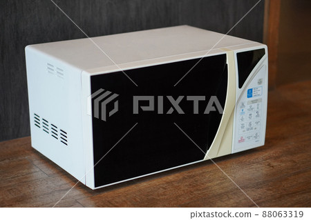 old white and cream microwave oven on wooden floor, grey wall background, technology, object, decor, copy space old white and cream microwave oven on wooden floor, grey wall background, technology, object, decor, copy space 88063319