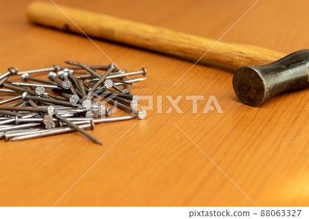 Hammer and iron nails on a wooden board 88063327
