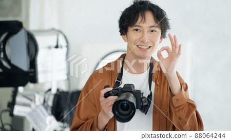 Male photographer shooting with a camera Male photographer shooting with a camera 88064244
