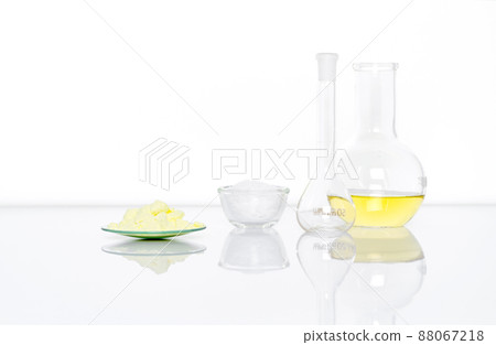 Sulfur Powder in Chemical Watch Glass place next to White flake chemical in glass container, Volumetric flask and Aluminium chloride liquid in Flat Bottom Flask.  Side View 88067218