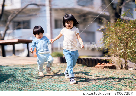 Image of siblings playing in the park Image of siblings playing in the park 88067297