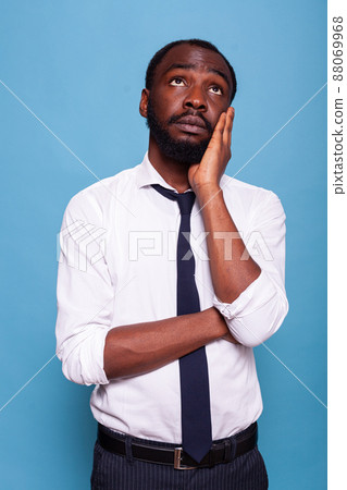 Portrait of employee in white shirt daydreaming looking up holding palm of hand to his face looking lost. Businessman having deep thoughts thinking about professional problems at work. Portrait of employee in white shirt daydreaming looking up holding palm of hand to his face looking lost. Businessman having deep thoughts thinking about professional problems at work. 88069968