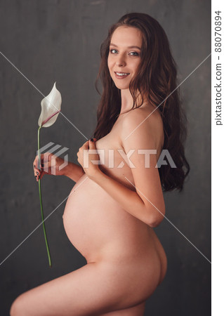 a beautiful slender naked pregnant woman with calla lily flower a beautiful slender naked pregnant woman with calla lily flower 88070894