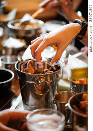 Hand taking baked chicken wing from a basket 88071862