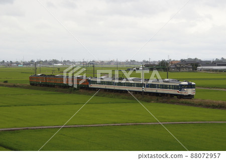 Echigo Line 115 series 6 cars going through the cloudy Niigata Plain Echigo Line 115 series 6 cars going through the cloudy Niigata Plain 88072957
