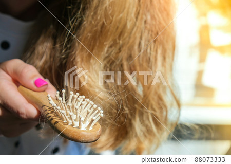 Hair loss on the comb, massage wooden brush with a clump of hair, problem of growth, hair care. Hair loss it cause from family history, hormonal changes, unhealthy of aging. Hair loss on the comb, massage wooden brush with a clump of hair, problem of growth, hair care. Hair loss it cause from family history, hormonal changes, unhealthy of aging. 88073333