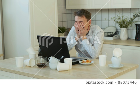 Exhausted Man Freelancer Overwhelmed with Job, Using Laptop All Night Long. Drinking from Coffee Pot. Working Overtime and Remote Work Concept Exhausted Man Freelancer Overwhelmed with Job, Using Laptop All Night Long. Drinking from Coffee Pot. Working Overtime and Remote Work Concept 88073446