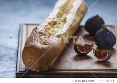 FRESH CRUNCHING BAGUETTE AND FIGS IN CLOSEUP ON TABLE FRESH CRUNCHING BAGUETTE AND FIGS IN CLOSEUP ON TABLE 88074023