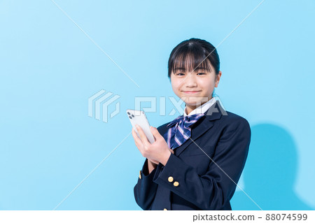 Junior high school girl looking at a smartphone Junior high school girl looking at a smartphone 88074599