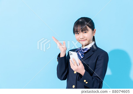 Junior high school girl looking at a smartphone Junior high school girl looking at a smartphone 88074605