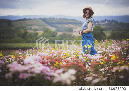woman standing in blooming flower garden with relaxing mood 88075300