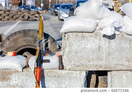 A hand grenade launcher at a checkpoint made of reinforced concrete blocks against the backdrop of a city street in Kyiv. 88075386