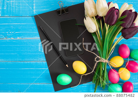 Easter eggs and tulips on blue wooden planks 88075482