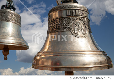 Orthodox bells closeup against the sky with clouds. New Jerusalem in town Istra, surroundings of Moscow, Russia. Orthodox bells closeup against the sky with clouds. New Jerusalem in town Istra, surroundings of Moscow, Russia. 88076969