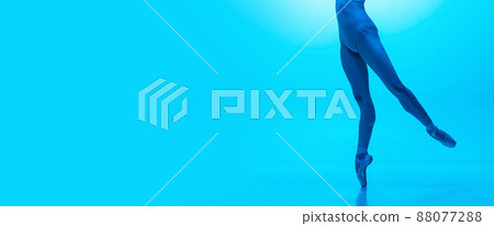 Flyer. Close-up ballerina's legs in pointe shoes isolated on navy color studio background in neon. Art, motion, action, flexibility, inspiration concept. 88077288