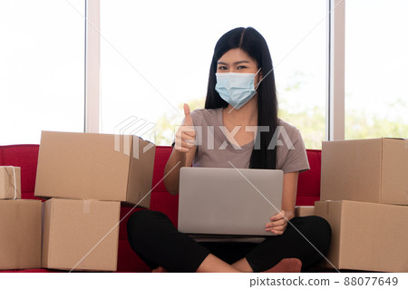 Happy young Asian women entrepreneurs on a mask are show thumbs up For joy With the success in business. Small business owner and success in online business concepts. Symbol of success 88077649