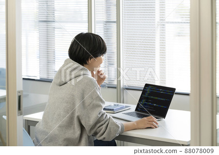Back view of a woman working on a laptop 88078009