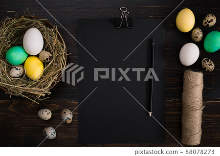 Colorful easter egg in nest on dark wood board. 88078273
