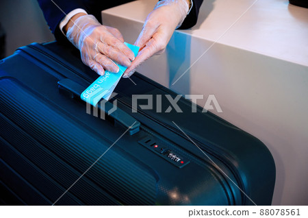 Airport ground stafft sits at the counter, weighing luggage and registration Airport ground stafft sits at the counter, weighing luggage and registration 88078561