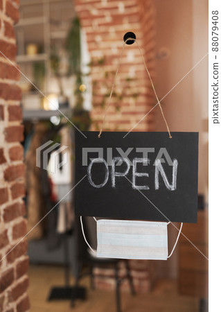 No people shot of black paper sign with word Open and protective mask hanging on glass door in modern cafe 88079408