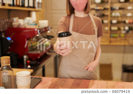 Medium section shot of unrecognizable female barista standing at counter giving cup of coffee to customer, copy space Medium section shot of unrecognizable female barista standing at counter giving cup of coffee to customer, copy space 88079419