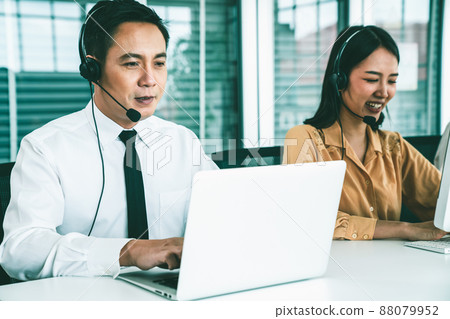 Business people wearing headset working actively in office Business people wearing headset working actively in office 88079952