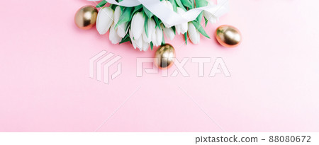Golden eggs with spring white tulips on pastel pink background in Happy Easter decoration. Foil minimalist egg design, modern top view banner design. 88080672