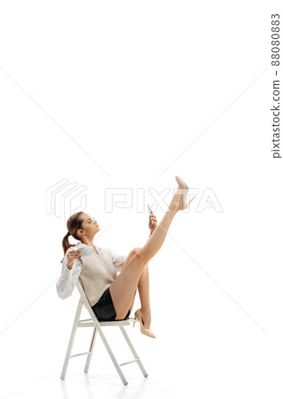 Portrait of young pretty girl, office worker in stylish cloth sitting, having online video call isolated over white studio background 88080883