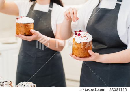 a women decorate icing, dried berries and flowers easter cakes. a women decorate icing, dried berries and flowers easter cakes. 88081113