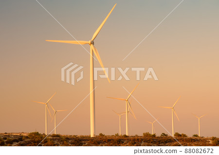 Group of wind power station for renewable electric energy production. Windmills on the sunset. High wind turbines for generation electricity. Group of wind power station for renewable electric energy production. Windmills on the sunset. High wind turbines for generation electricity. 88082672