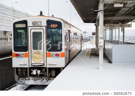 [Johoku Line] Train that stops at Ajiyoshi Station in the snowy landscape 88082673