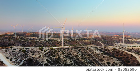 Group of wind power station for renewable electric energy production. Windmills on the sunset. High wind turbines for generation electricity. Group of wind power station for renewable electric energy production. Windmills on the sunset. High wind turbines for generation electricity. 88082690