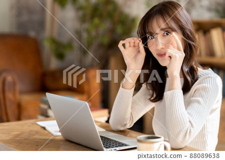 Woman with glasses using a laptop Woman with glasses using a laptop 88089638