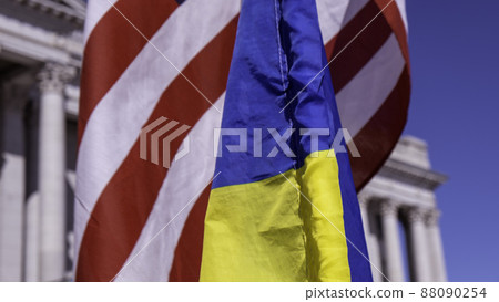 Close up of US, Ukraine flags on poles overlapping with capitol building in background. High quality photo Close up of US, Ukraine flags on poles overlapping with capitol building in background. High quality photo 88090254