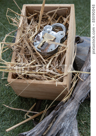 Old vintage iron padlock on straw background in wooden box. Old vintage iron padlock on straw background in wooden box. 88090848