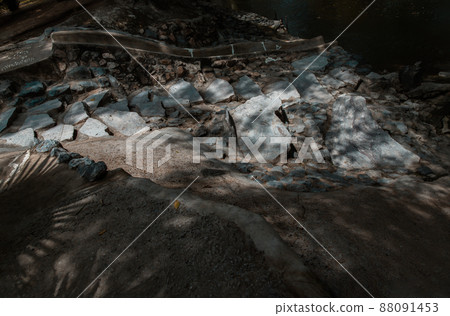 Sunbeams lighting down of stone slab at brookside. Sunbeams lighting down of stone slab at brookside. 88091453