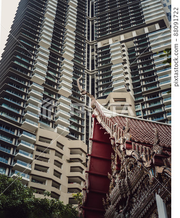 View of Buddhist thai temple with Modern tall condominium building in the background can coexist perfectly. View of Buddhist thai temple with Modern tall condominium building in the background can coexist perfectly. 88091722