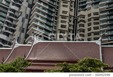 Roof of buddhist thai temple with Modern tall condominium building in the background can coexist perfectly. 88092096