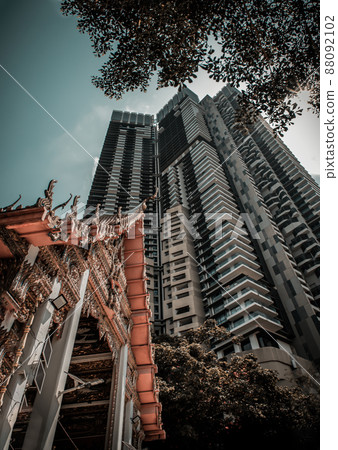 View of Buddhist thai temple with Modern tall condominium building and green trees in the background can coexist perfectly. View of Buddhist thai temple with Modern tall condominium building and green trees in the background can coexist perfectly. 88092102