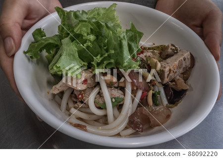 Hainan spicy rice noodle with braised pork in Thai style on stainless steel table. Very delicious local food with many kinds of ingredients. Oblique view from the top. Hainan spicy rice noodle with braised pork in Thai style on stainless steel table. Very delicious local food with many kinds of ingredients. Oblique view from the top. 88092220