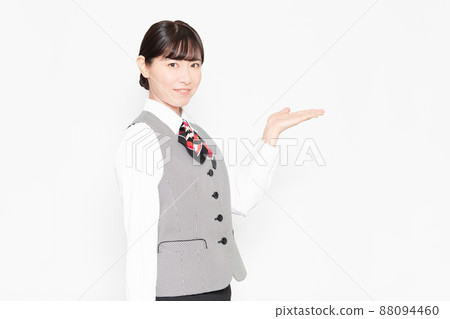 A business woman standing in front of a white wall and posing as a guide 88094460