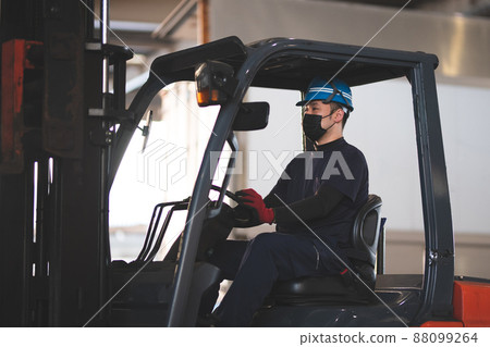 Man riding a forklift 88099264