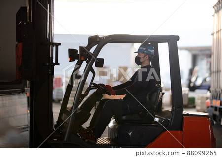 Man riding a forklift 88099265