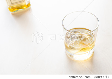 whiskey on the rocks in glass and bottle on table 88099917