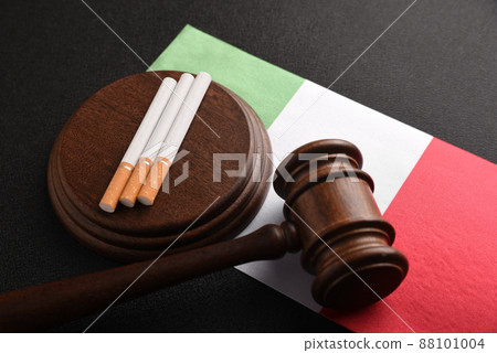 Cigarettes, wooden Judge gavel and flag of Italia. Tobacco law. Legal responsibility for the sale and purchase of cigarettes. Smoking in Italy. 88101004