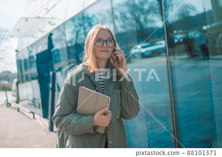 Smiling young girl in casual clothes using mobile phone Smiling young girl in casual clothes using mobile phone 88101371