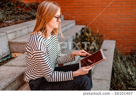 Beautiful young woman using tablet in the city 88101407