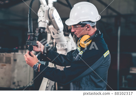 Young factory worker working with adept robotic arm 88102317