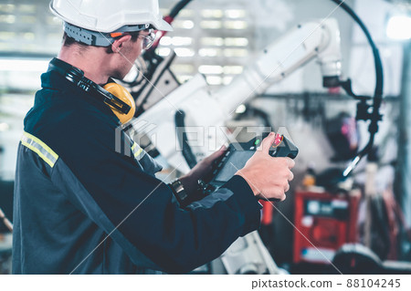 Young factory worker working with adept robotic arm 88104245