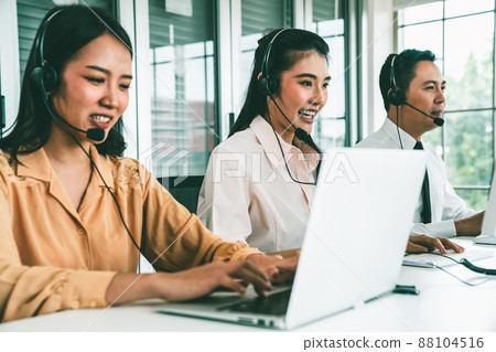 Business people wearing headset working actively in office Business people wearing headset working actively in office 88104516